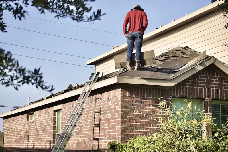 Professional roofer working on a residential roof in Brookfield West